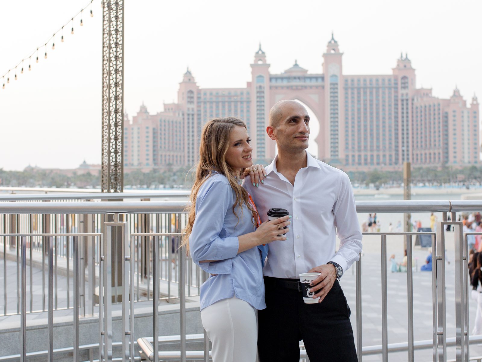 Olena Kysla und Mohanad Almeshal beim Kaffee an der Uferpromenade der Palm Jumeirah, hinter ihnen das Atlantis The Palm